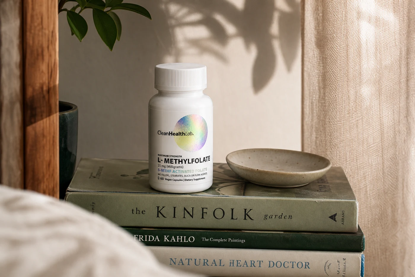 A CleanHealthLab bottle on a stack of books in dappled afternoon light