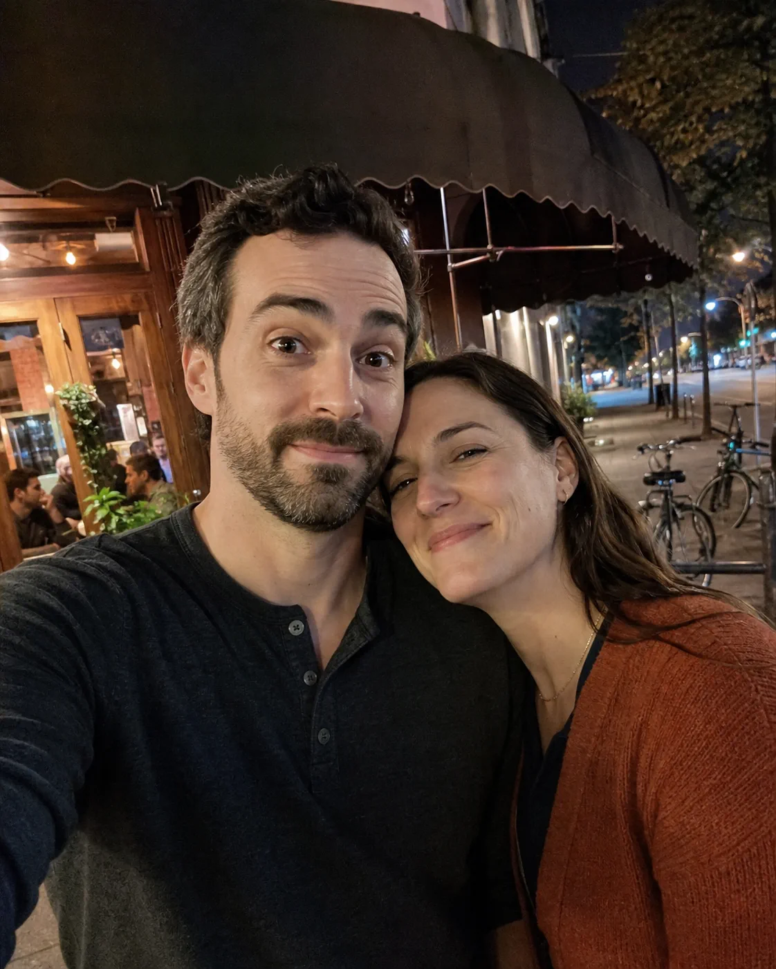 Happy couple taking an informal phone selfie after dinner